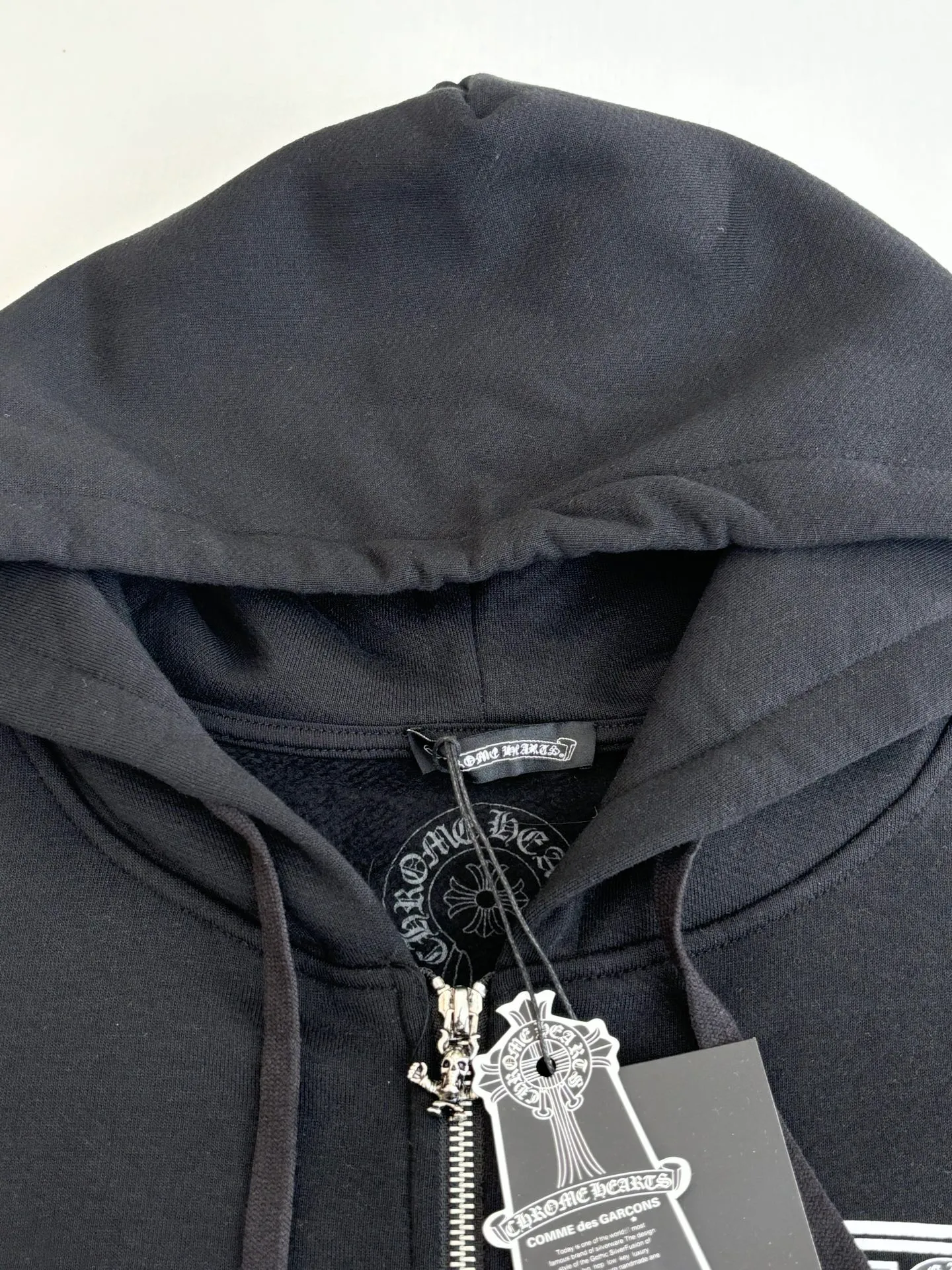 P426 Chrome Heart*/Chrome Heart Jiugongge skull hooded zipper sweatshirt is made of high-quality cotton fabric, soft and skin-friendly, and has good breathability. The overall color is classic black, which sets a low-key and versatile style tone. The simple print pattern on the left chest on the front includes letters and cartoon skull images. The design is simple but highly recognizable, showing an uninhibited personality and attitude. Size: S/M/L/XL